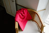 525 America Women's High-Quality Sweaters Collection showcasing elegant pink knitwear on a stylish wooden chair.