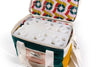 A colorful insulated cooler bag with a geometric pattern is open, showing a compartmentalized white tray inside.
