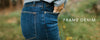 Close-up of a person wearing blue jeans with one hand in the back pocket. The text 