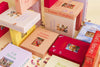 Stacked puzzle boxes in various colors with titles such as 