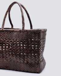 Handwoven leather tote by Dragon Diffusion against a light background.