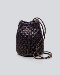Dragon Diffusion woven leather Pom Pom Double Jump bucket bag with tassel detail on gray background.