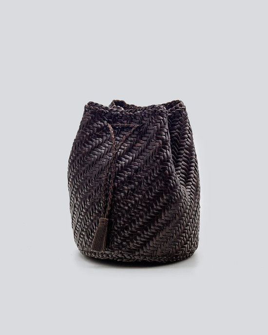 Pom Pom Double Jump in Dark Brown woven leather bucket bag on a neutral background by Dragon Diffusion.