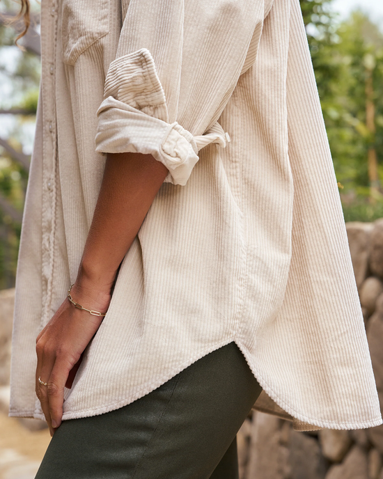 Close-up of a person wearing a Shirley Oversized Button Up in Vintage White Cotton by Frank & Eileen with the sleeve rolled up, displaying a simple bracelet and a ring on the wrist.