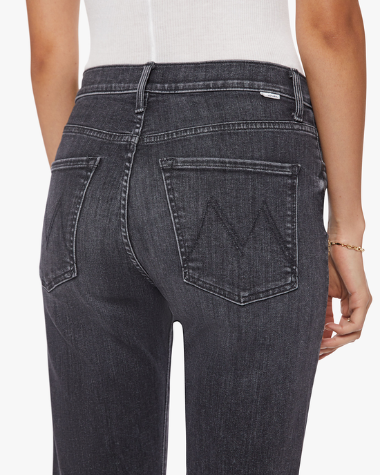 Close-up of a woman wearing The Ditcher Zip Ankle in Smoking Section denim jeans from Mother with distinctive pocket stitching.