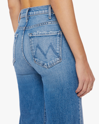 Woman wearing blue Mother high-rise denim jeans, side view focusing on the back pocket of The Hustler Roller Ankle in High On The Hog.