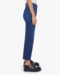 Side view of a person wearing blue Mother High-Waisted Fit jeans and black platform loafers.