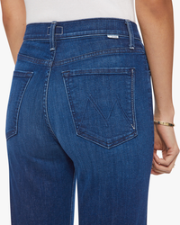 Close-up of a person wearing blue jeans, focusing on the back pocket design, showcasing the Mother High-Waisted Fit Rambler Zip Ankle in Animal Instinct.
