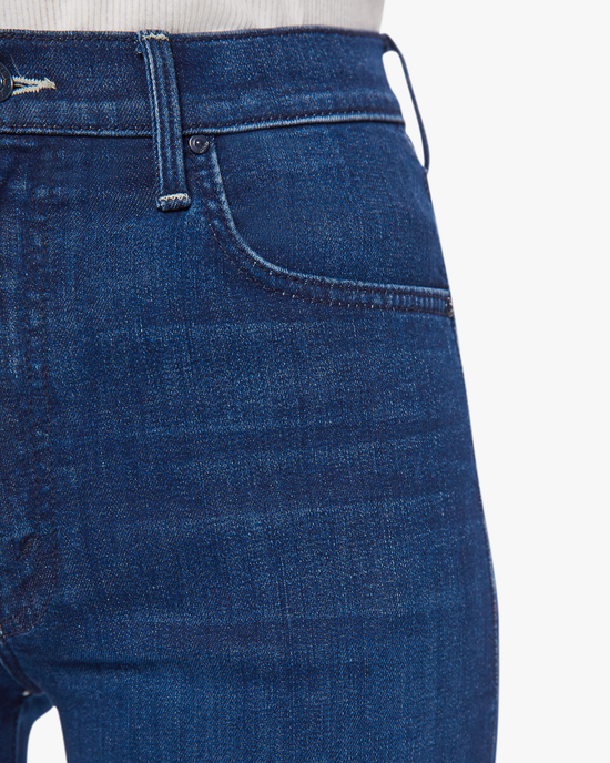 Close-up of a person wearing Mother's Rambler Zip Ankle in Animal Instinct high-waisted fit jeans with a focus on the pocket detail.