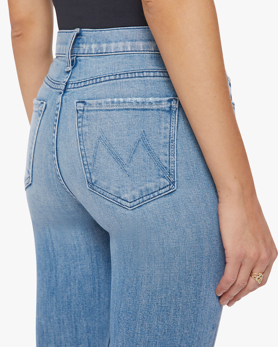 Woman wearing Mother Denim The Rascal Skimp blue jeans with a distinctive back pocket design and a charming mid-rise straight leg.