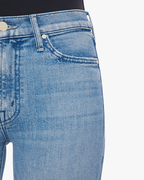 Close-up of a person wearing blue Mother Denim jeans, focusing on the pocket detail of The Rascal Skimp in Punk Charming with a charming mid-rise straight leg and ankle grazing inseam.