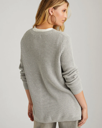 Woman wearing a lightweight cotton 525 gray ribbed sweater viewed from behind.