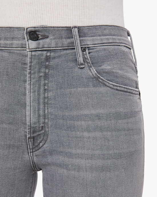 Close-up of a person wearing gray, high-waisted bootcut jeans: The Insider Crop Step Fray in Barely There by Mother.