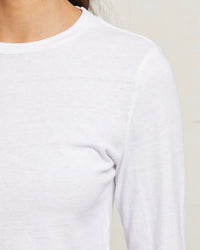 Close-up of a woman wearing the perfectwhitetee Jamie Recycled Cotton L/S in White, featuring soft, slightly textured recycled cotton. The focus is on the chest and shoulder area against a neutral background.