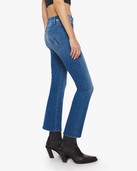 Woman wearing blue high rise flare jeans and black ankle boots, The Hustler Ankle in One Trick Pony by Mother.