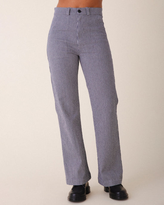 A person wearing Prairie Underground’s Long Smithy Pant in Oyster with a straight-leg fit and black shoes stands against a plain light background.