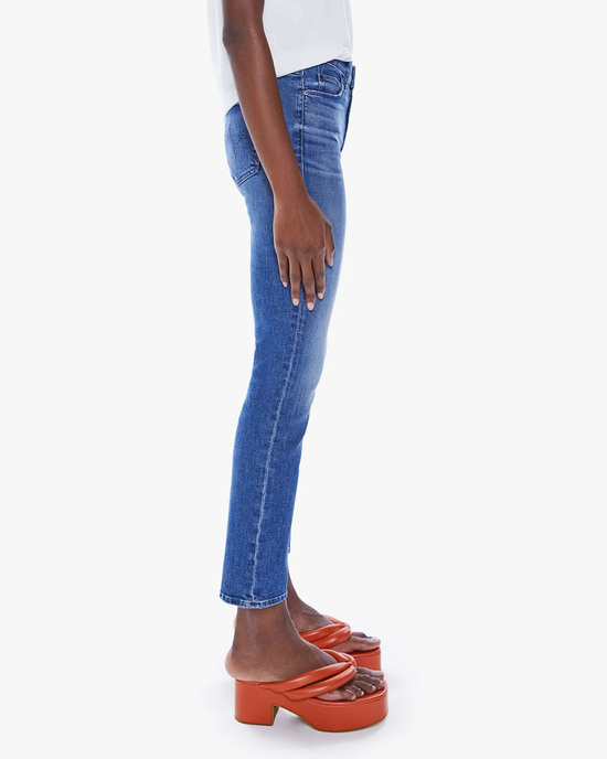 Side view of a person standing in Mother's The Mid Rise Dazzler Ankle in Wish On A Star denim jeans and orange platform sandals.