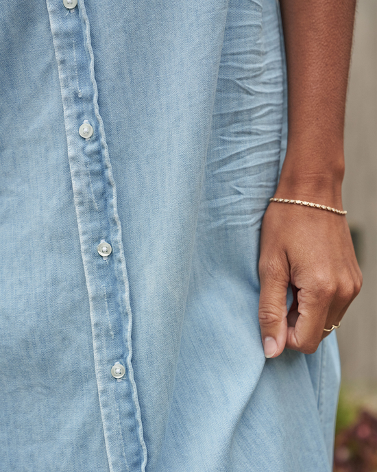 Close-up of a person's side wearing a Frank & Eileen Rory Maxi Shirtdress in Classic Blue w/ Tattered Wash and a bracelet.