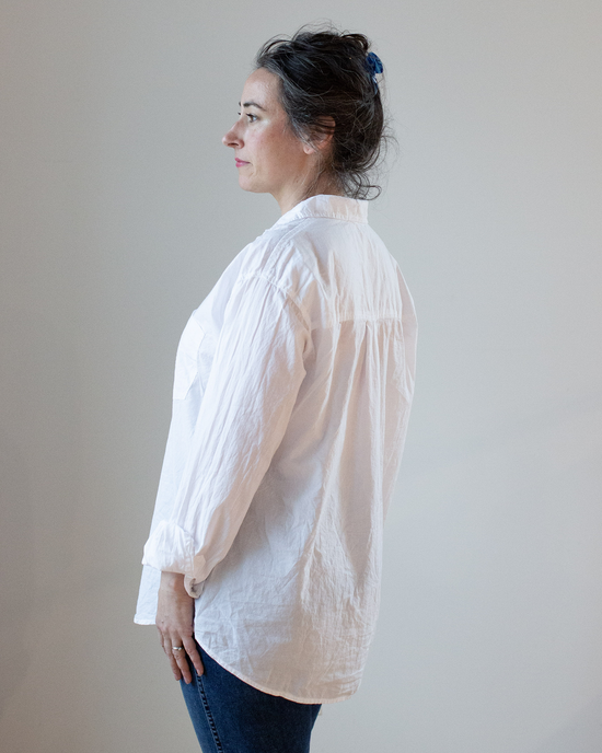 Woman standing in profile against a neutral background, wearing an oversized CP Shades Joss 1 Pocket in White Cotton Oxford button-up.
