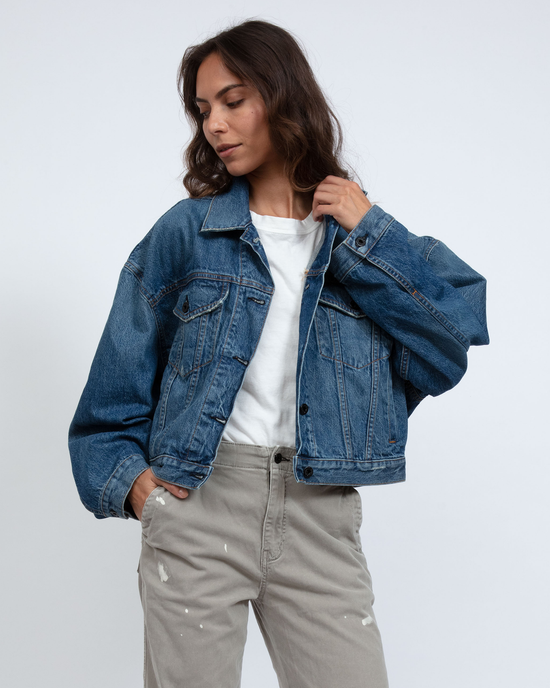 Woman posing in a Denim Jacket in Nova by ASKK NY with an oversized long sleeve and casual trousers against a plain background.