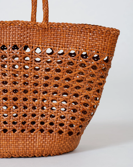 Woven brown Dragon Diffusion Cannage Market XL in Tan handwoven leather tote bag with openwork design on white background.