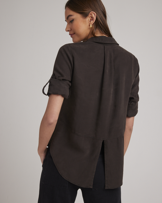 Woman in a Bella Dahl Quartz Brown Split Back Button Down shirt viewed from behind with a focus on the upper body and split back button down design of the shirt.