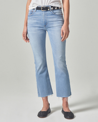 Woman wearing light blue Isola Cropped Boot in Marquee jeans with frayed hems and black slip-on shoes from Citizens of Humanity.