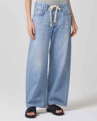 Wide-leg Citizens of Humanity Brynn Trouser in Blue Lace with drawstring waistband and black sandals.