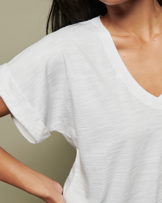 A woman in a Nation LTD Stevie Cuffed V Neck in White, with the focus on her shoulder and neckline.