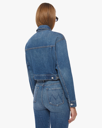 Rear view of a person wearing a Mother Out Of Pocket Jacket in Morning Chores denim jacket and jeans.