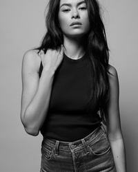 Monochrome portrait of a woman in a Nation LTD Joan Sleeveless Mock Neck in Jet Black top and jeans looking at the camera.