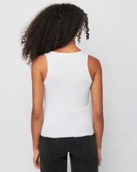 Woman from behind wearing a white Nation LTD Tarin Racerback Cowl and black jeans.