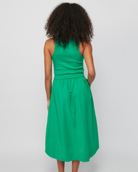 A woman seen from behind wearing a Nation LTD Sadelle Clean Combo Midi in Island Time dress against a white background.