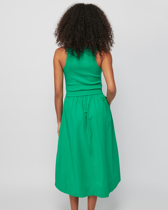 A woman seen from behind wearing a Nation LTD Sadelle Clean Combo Midi in Island Time dress against a white background.