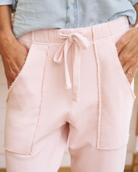 Close-up view of a person wearing pink Frank & Eileen Eamon Jogger sweatpants in Vintage Rose with hands resting on the hips.