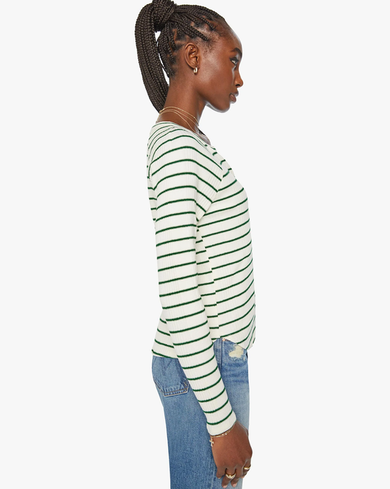Side view of a woman wearing the Mother Split Varsity Long Sleeve in High Road Stripe top with a split crewneck and blue jeans.