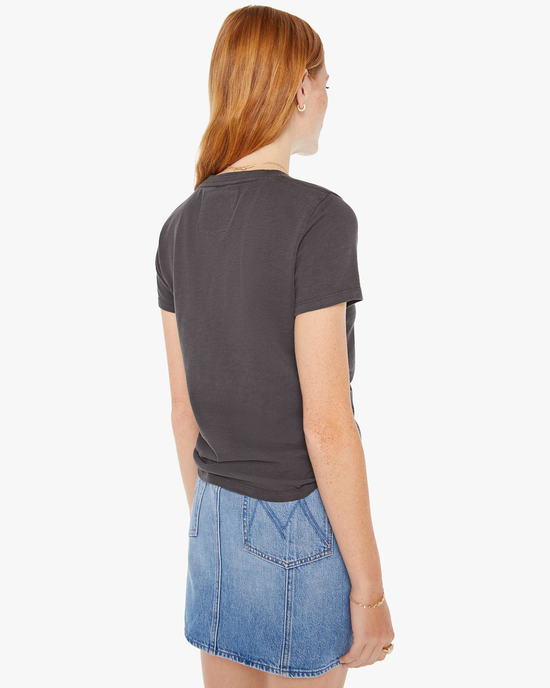 Woman from behind wearing a grey vintage inspired graphic tee and a blue Mother Denim skirt.