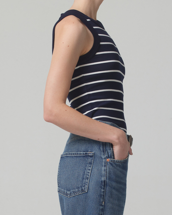 Woman wearing a Citizens of Humanity Isabel Tank in Midnight Stripe made of organic cotton rib and blue jeans standing sideways.
