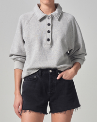 Woman wearing a gray organic cotton Phoebe Pullover sweatshirt and black denim shorts from Citizens of Humanity.