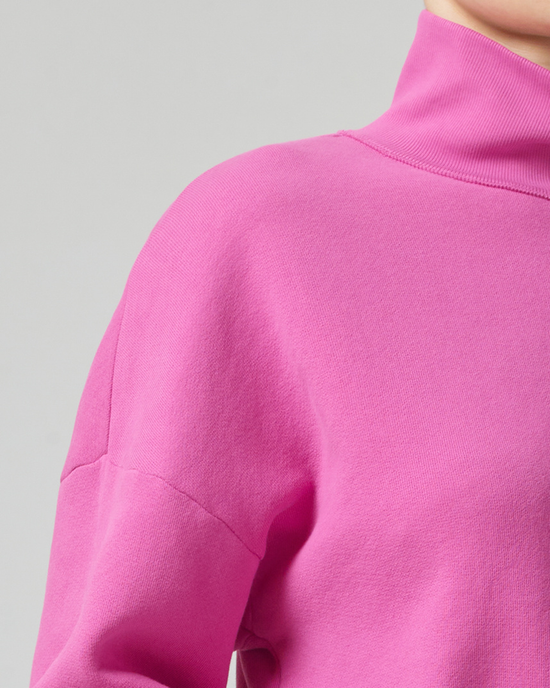 Close-up of a person wearing a relaxed, cropped fit Koya Turtleneck in Rosey by Citizens of Humanity.
