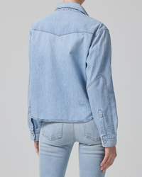 Person wearing a high waist denim jacket and jeans from the back view of a Cropped Western Shirt in Pharos by Citizens of Humanity.