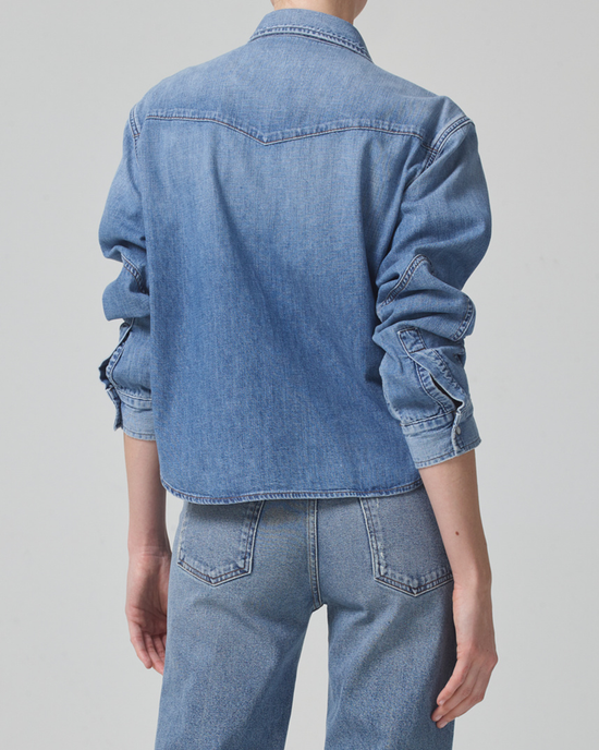 A person wearing a Citizens of Humanity Cropped Western Shirt in Carolina Blue and jeans, viewed from the back.