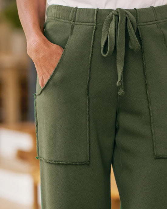 A person wears Frank & Eileen's Penny Patch Pocket Sweatpant in Caper, featuring a relaxed fit, large patch pockets, visible stitching, and a casual, comfortable style.