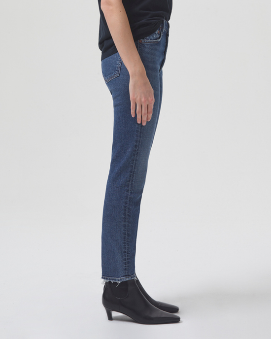 Person standing side-on wearing AGOLDE Nico Hi Rise Slim Fit in Limit jeans and black boots.