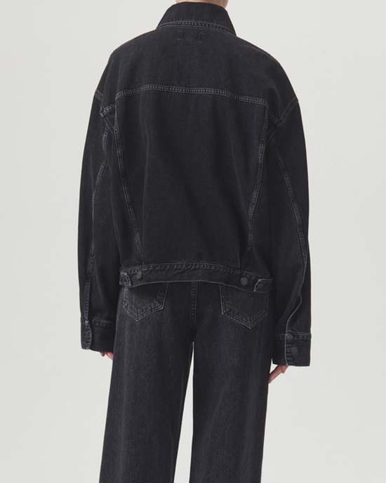 A person from behind wearing a black non-stretch denim AGOLDE Martika Jacket in Spider and jeans.
