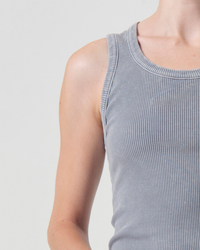Close-up of a person wearing a gray sleeveless ribbed AGOLDE Poppy Scoop Neck Tank in Mirror Ball, focusing on the shoulder and part of the torso, against a white background.