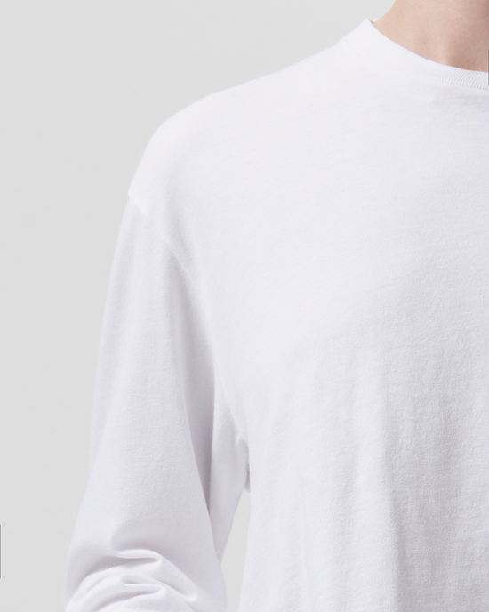 Close-up of a person wearing an AGOLDE Mason Cropped Tee in White against a light background.