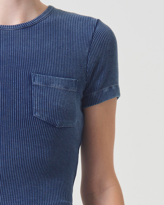 Close-up of a person wearing an AGOLDE Arlo Rib Pocket Tee in Indigo with a pocket on the left side, focus on the upper torso.