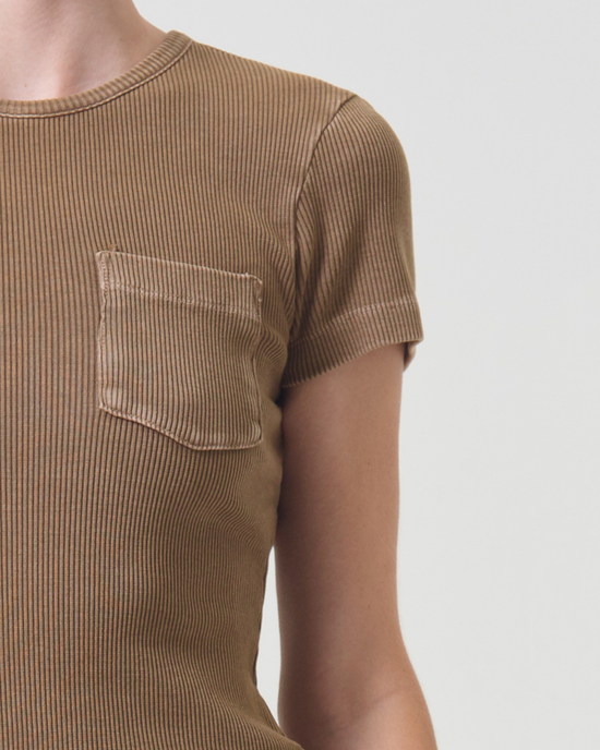 A close-up of a person wearing an AGOLDE Arlo Rib Pocket Tee in Bamboo, focusing on the torso and shoulder area.