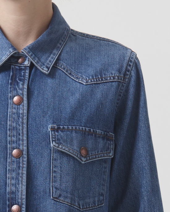 Close-up of a relaxed Glinda Shirt in Rhythm denim jacket with copper buttons by AGOLDE.